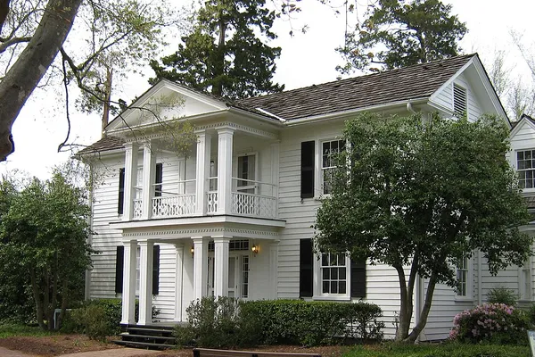 White two-story farmhouse with a porch at Historic Oak View County Park